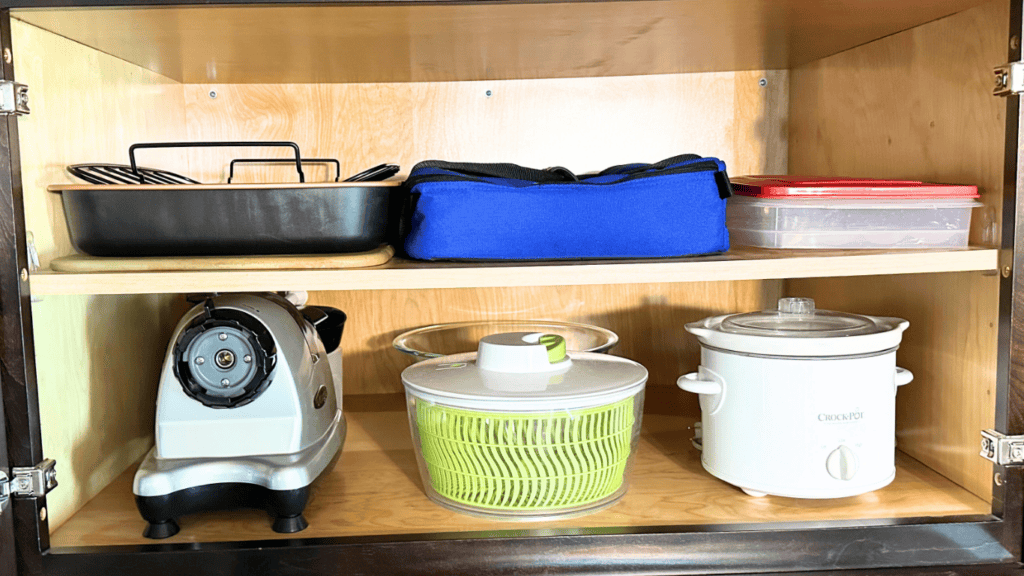 small kitchen appliances in shelf above refrigerator