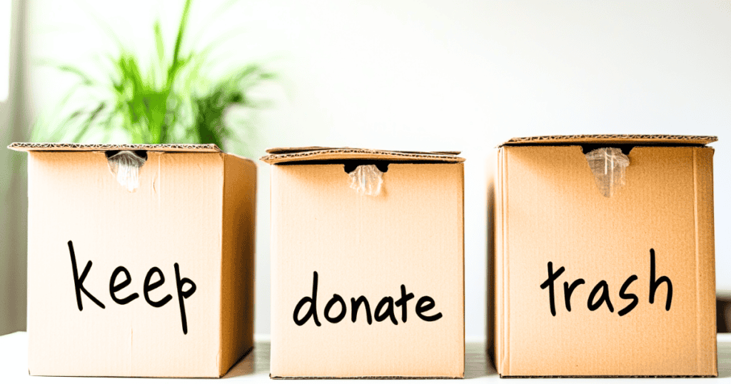 Three cardboard boxes labeled "keep", "donate" and "trash"