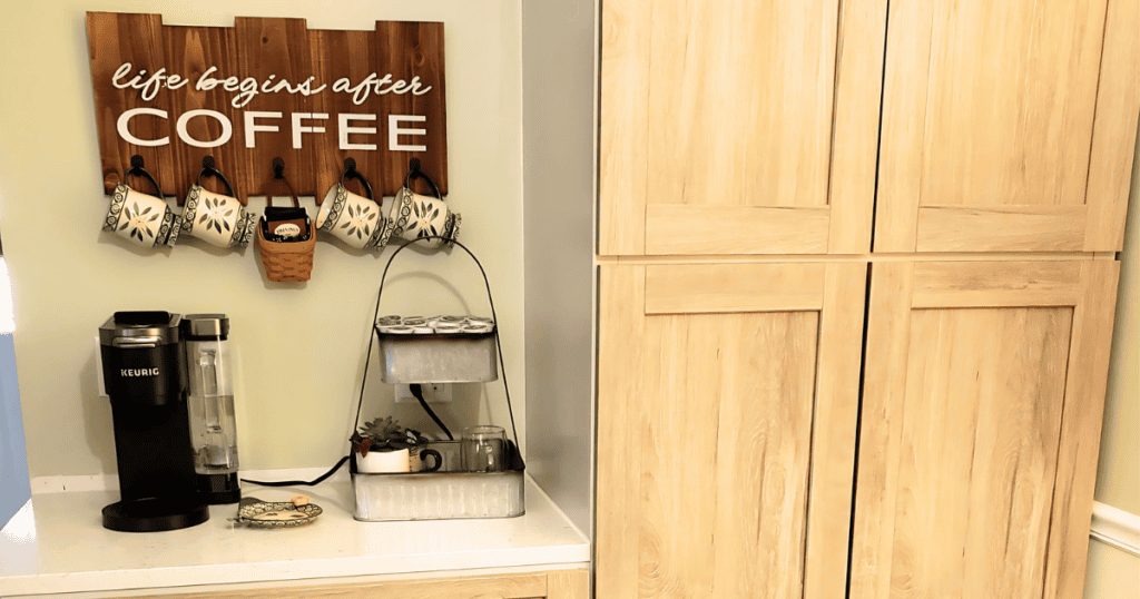 coffee bar in kitchen with light cabinets and coffee sign on the wall