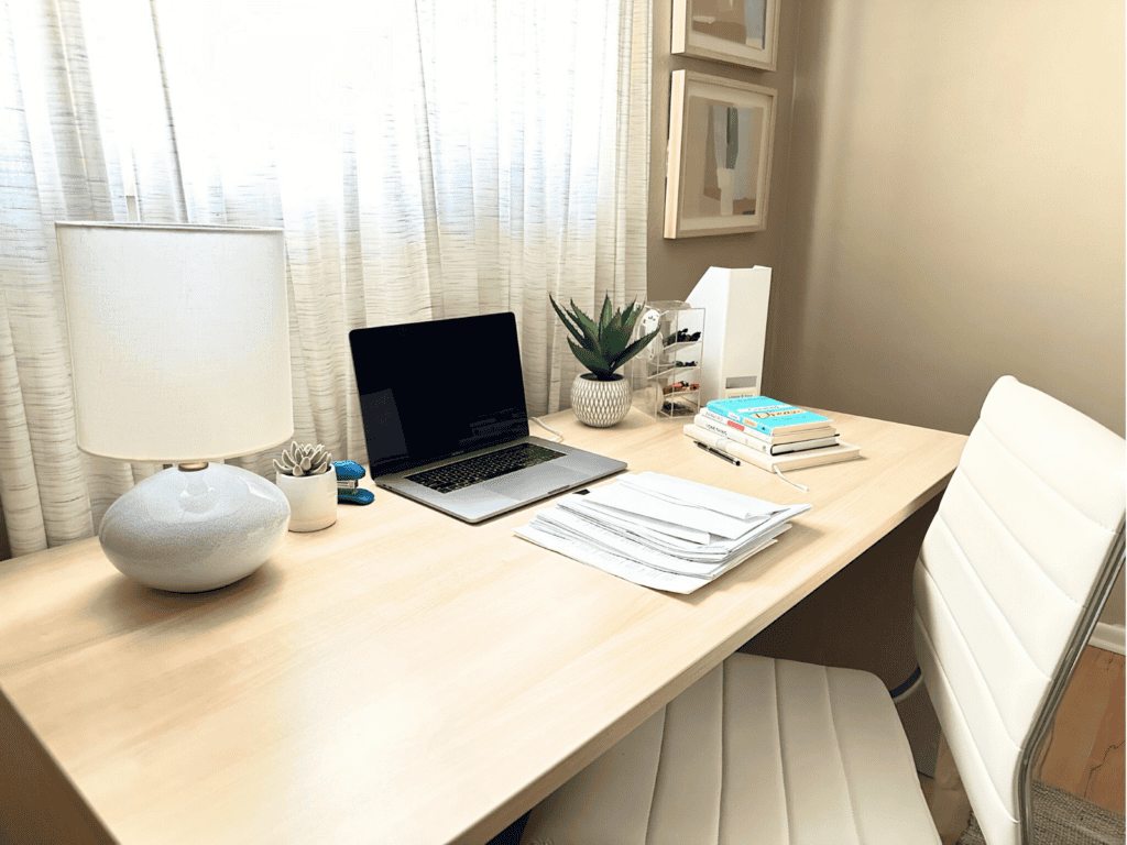 The desk in my home office cluttered with papers and books