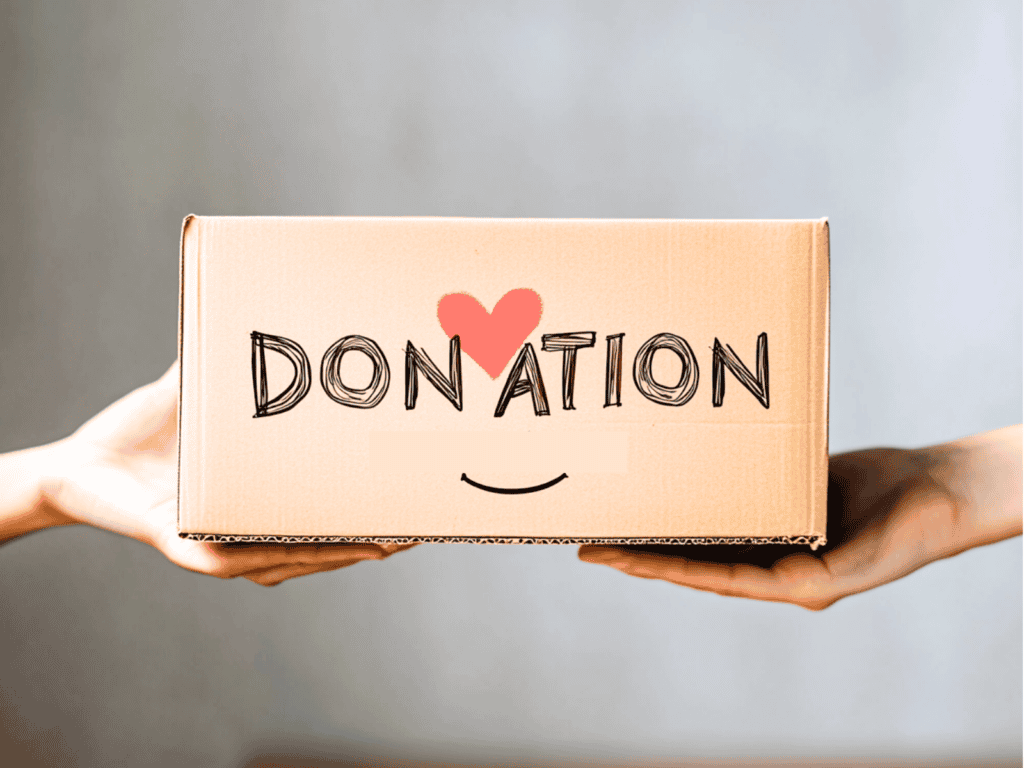 A cardboard box that says "donation" and it has a heart and a smiley face on it