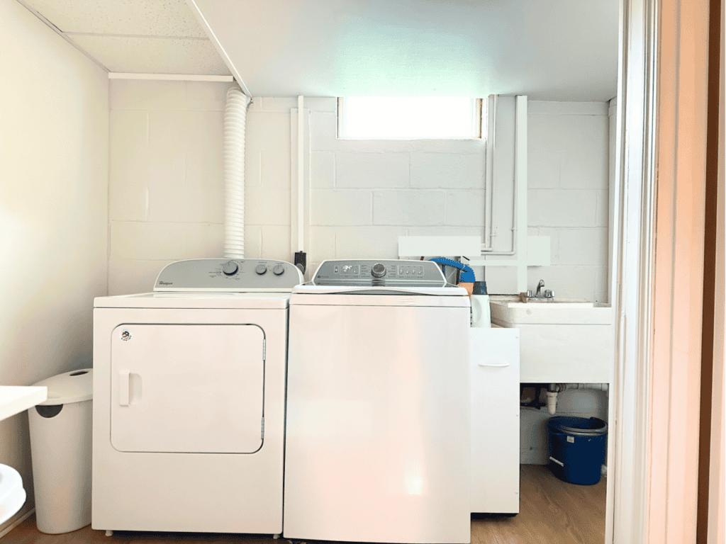 Washer, dryer, and rolling storage cart in a laundry room