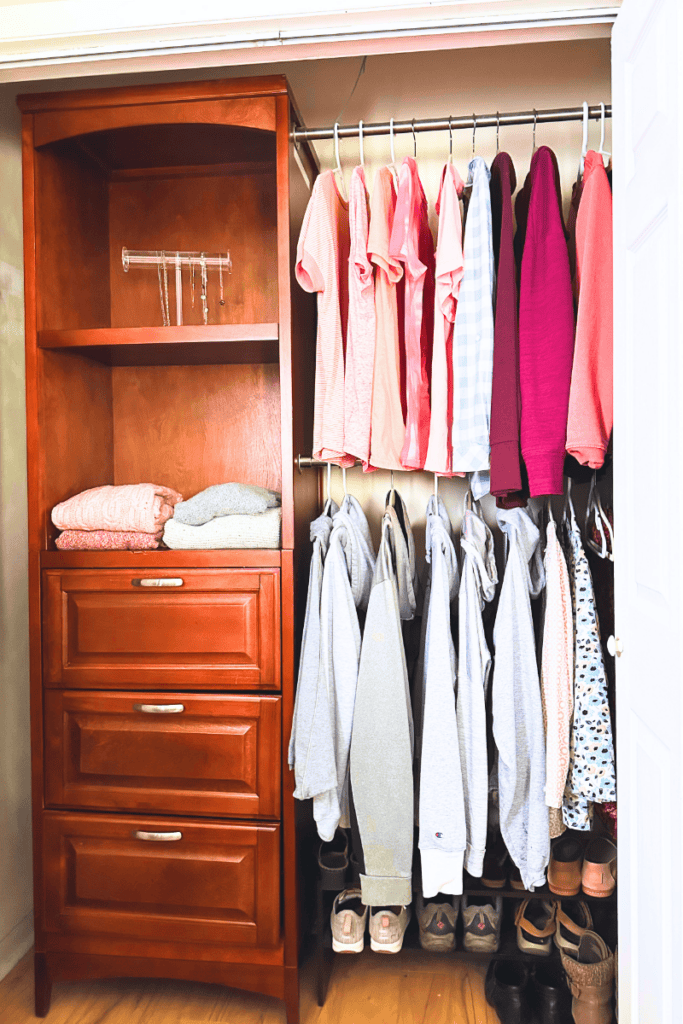 Bedroom closet with double hanging rods, drawers, shelves, and a shoe rack