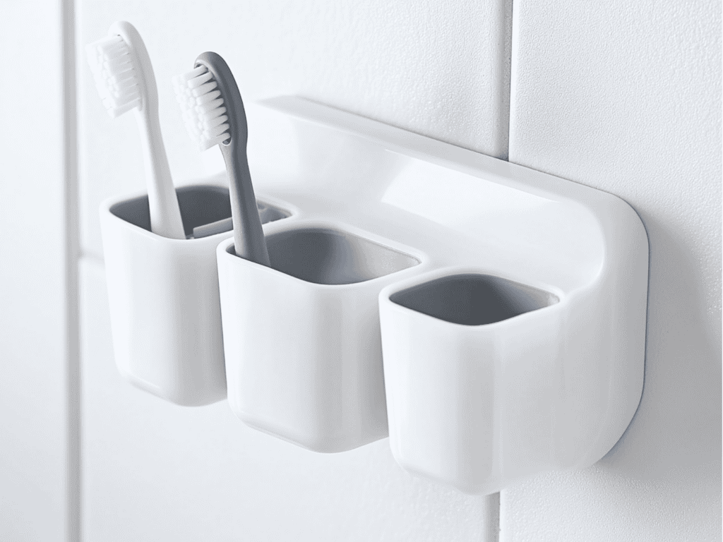 A white toothbrush holder mounted on the wall