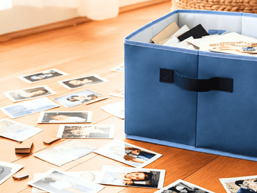 A box filled with sentimental items and pictures lay on the floor around the box