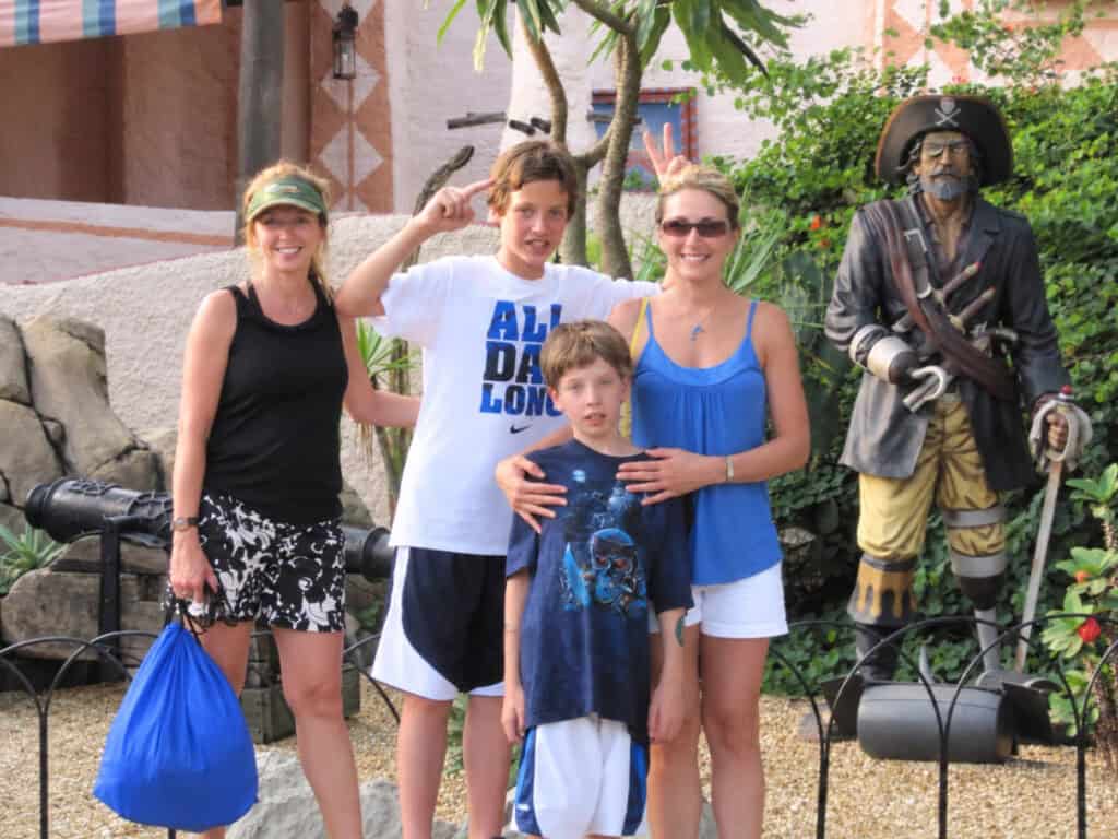 Me with my family at Disney World, I am wearing a necklace and carrying the purse that my nephew bought me.