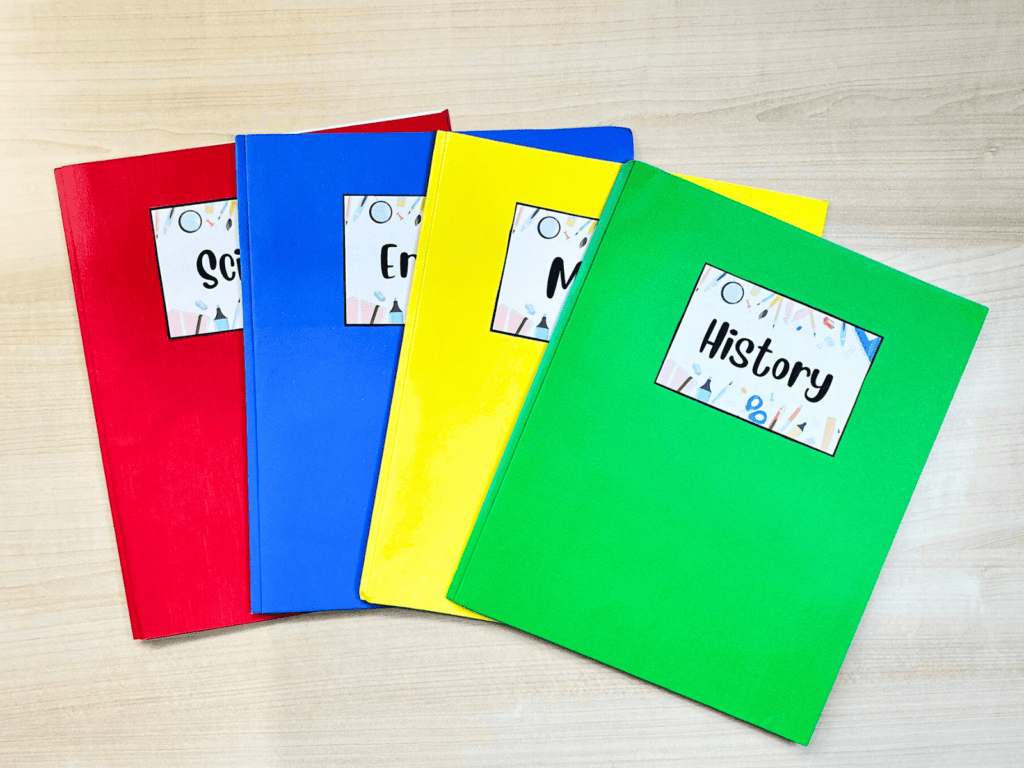 Red, blue, yellow, and green folders with labels for homework subjects