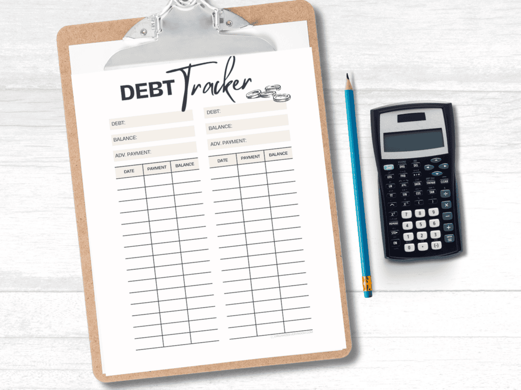 A debt tracker sheet on a clipboard beside a calculator and a pencil.