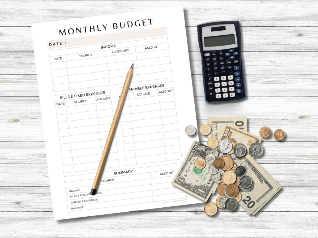 A monthly budget page with a calculator, pencil, and money laying beside it.