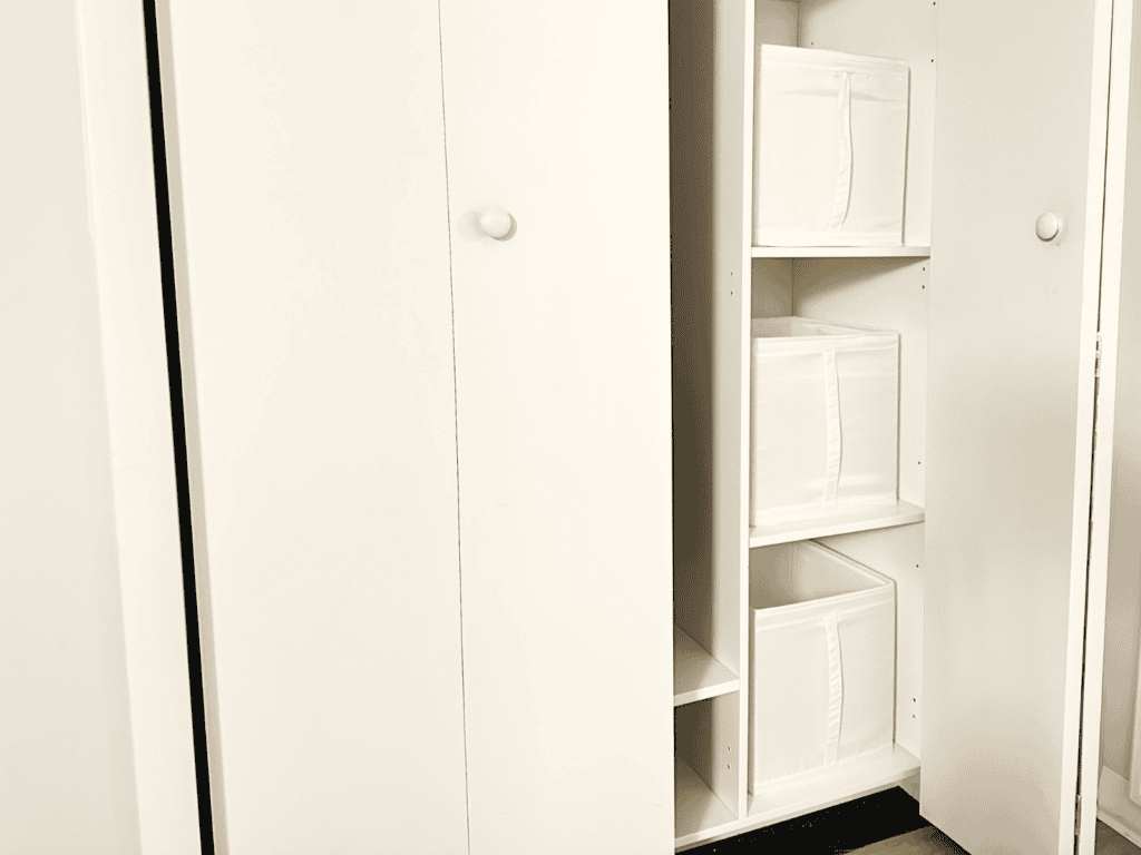 Three cream colored totes in the closet of my spare bedroom.