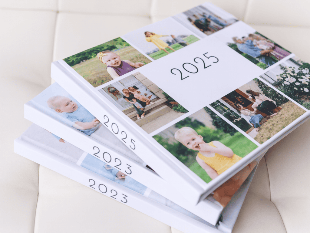 Stack of three photo yearbooks labeled 2023, 2024, and 2025, featuring collage-style covers with family and childhood photos, arranged on a soft white surface.