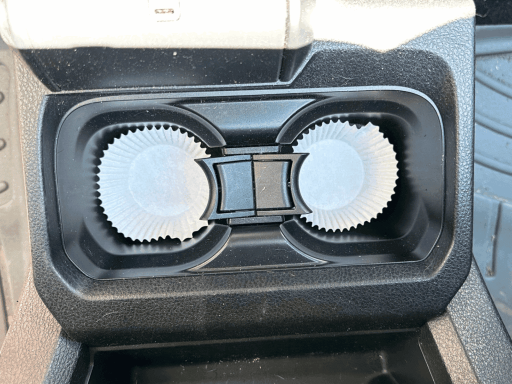 Car cup holders lined with paper cupcake liners to catch crumbs and spills, making it easy to keep the holders clean.