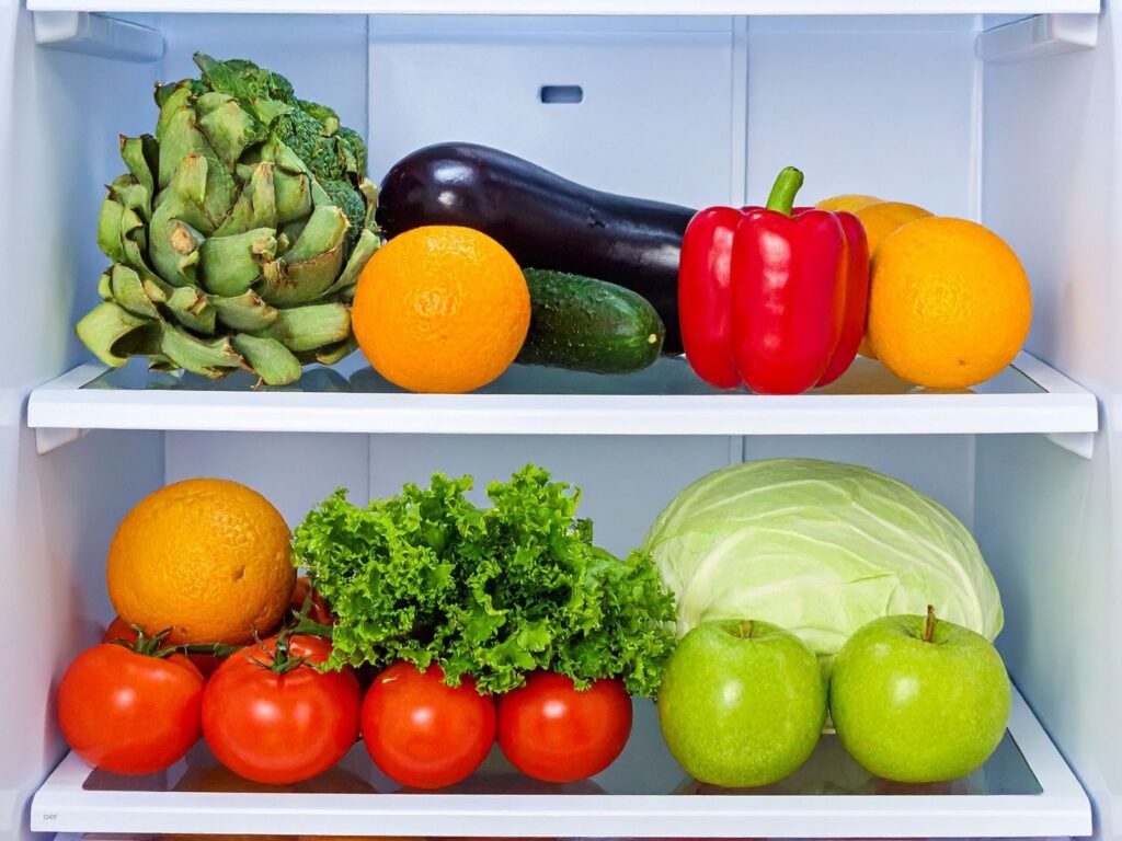 An organized refrigerator shelf with fresh produce, containers, and open space, showing a simple five-minute fridge decluttering task.